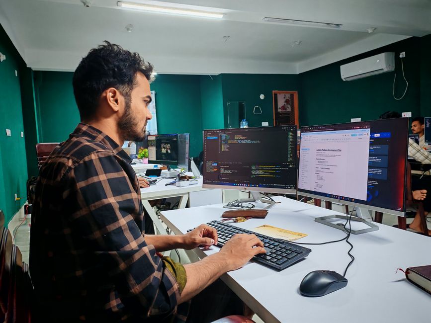 Programer radi na kodu na postavci s dva monitora u modernom uredu.